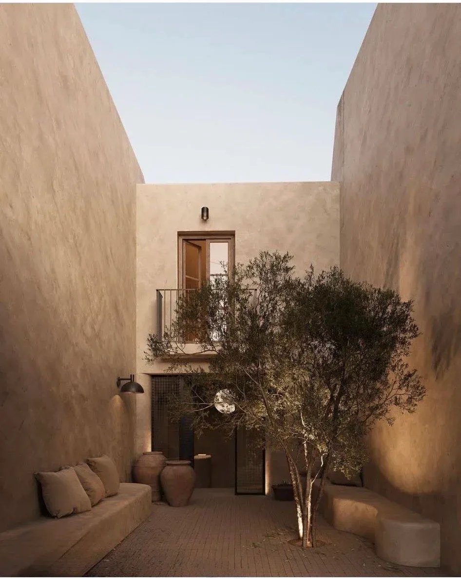 Earth-toned courtyard with an olive tree, built-in clay seating and terracotta pots