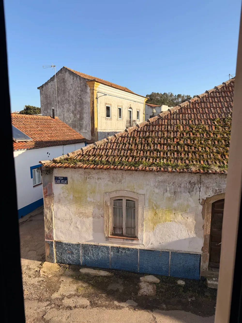 View from Casa Alma window over São Luís village rooftops with terracotta tiles