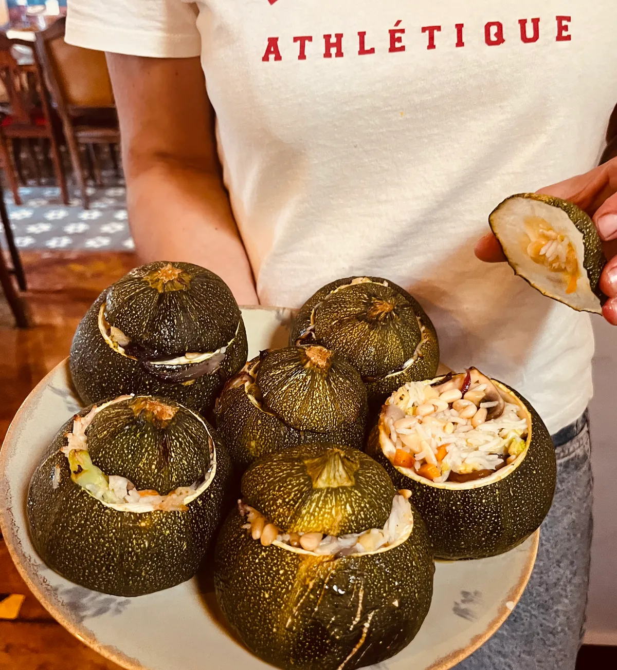 Plate of round courgettes stuffed with rice, beans and herbs, freshly prepared in the kitchen