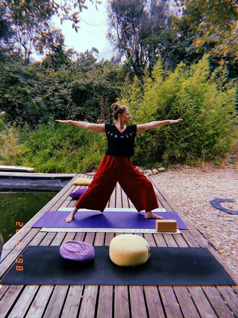 Clara Vidal in warrior pose on the outdoor yoga deck